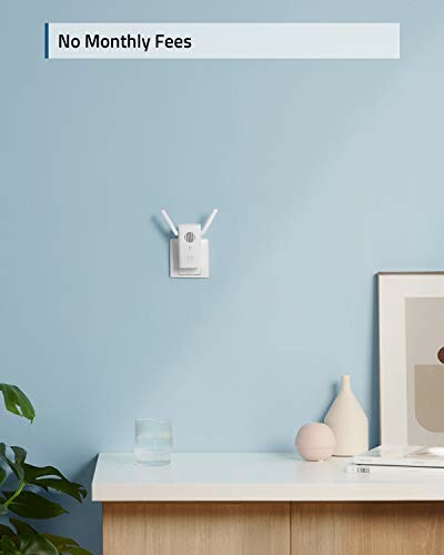 WiFi extender on a blue wall above a table with decor.